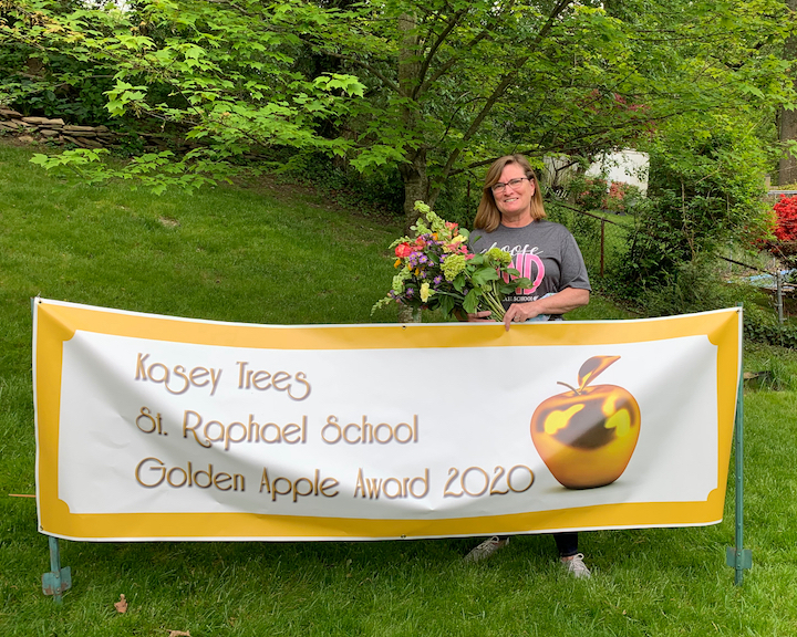 Teacher with congratulatory banner