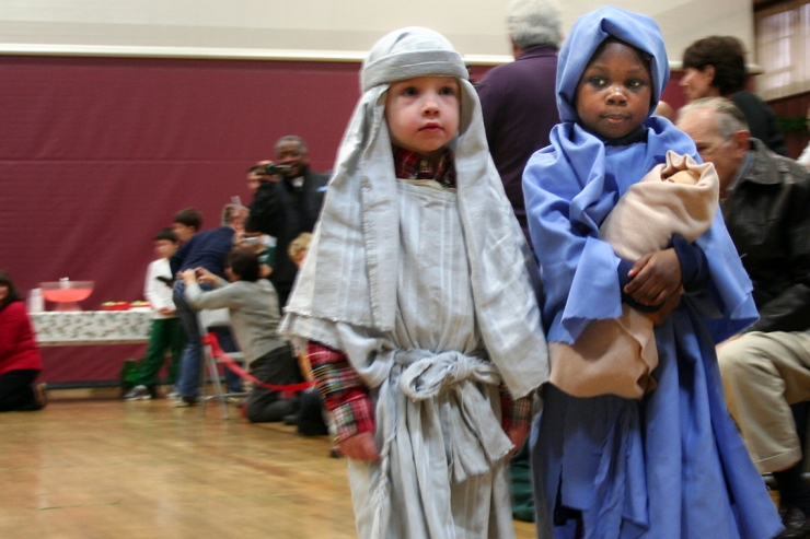 Preschoolers dressed as Mary and Joseph, holding baby Jesus