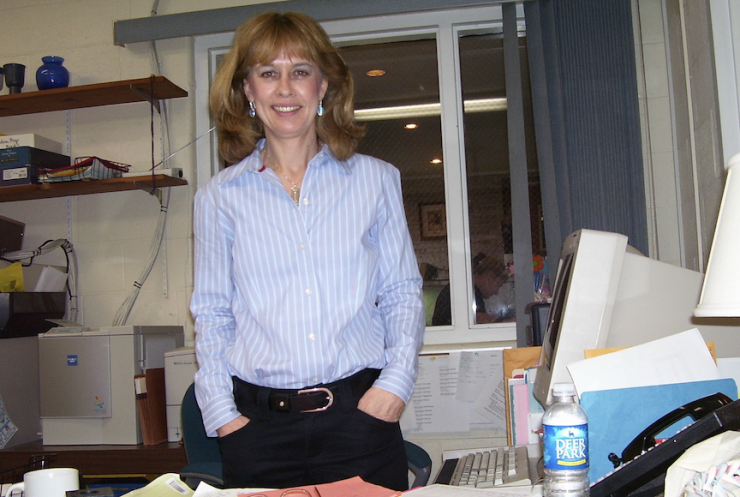School secretary standing by her desk